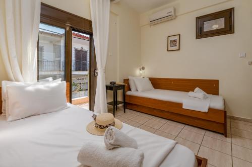 a hotel room with two beds and a balcony at Kripis Studio in Pefkochori