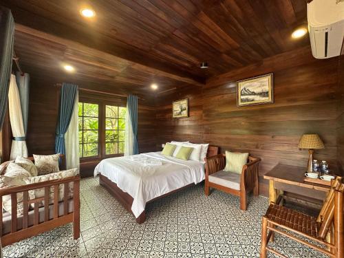 a bedroom with a bed in a room with wooden walls at MK Hill resort Phu Quoc in Phú Quốc