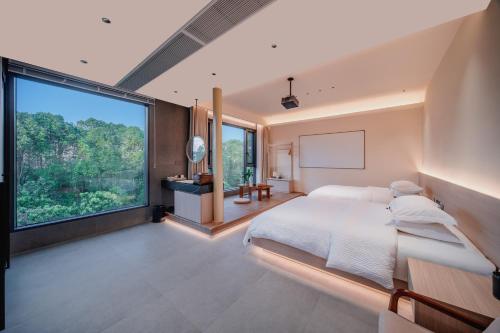 a bedroom with a bed and a large window at Zhangjiajie The Brookside Hotel& Tianmen National Forest Park & Free pick up service in Zhangjiajie