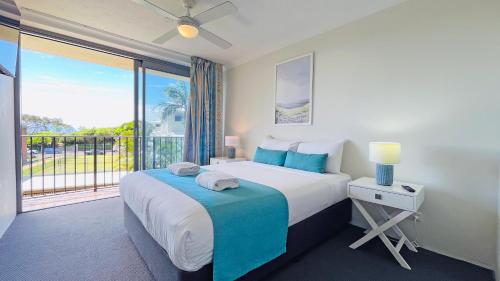 a bedroom with a bed and a large window at Majorca Isle Beachside Resort in Maroochydore