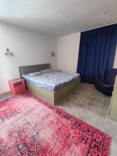 a bedroom with a bed and a red rug at LiLi Boutique in Dsegh