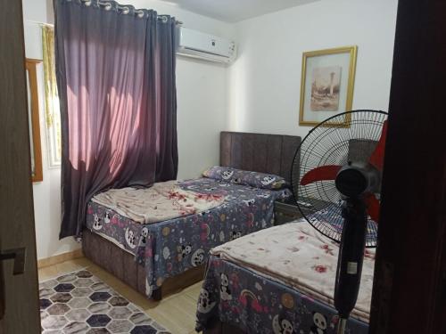 a room with two beds and a fan at قريه سورتلاج مرسي مطرح الفيو المميز in Marsa Matruh