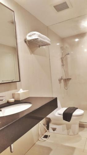 a bathroom with a sink and a toilet and a shower at Orchardz Hotel Bandara in Tangerang
