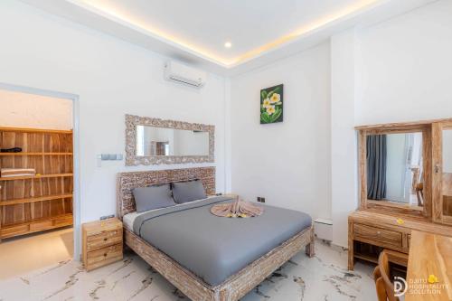 a bedroom with a bed and a mirror on the wall at Made's Dream Villa Amed in Amed