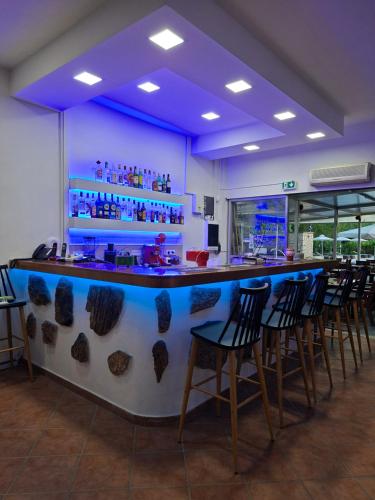 a bar in a restaurant with chairs around it at Angela Hotel & Apartments in Gouvia