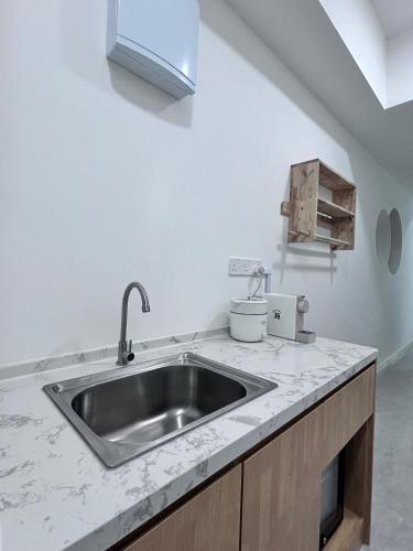 a kitchen with a sink and a counter top at Liwan, Baysuite by Ayuhouz in Kota Kinabalu
