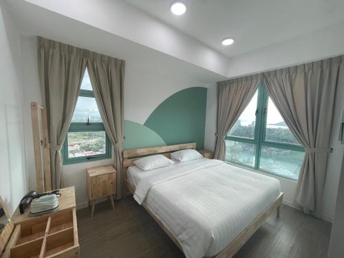 a bedroom with a large bed and two windows at Liwan, Baysuite by Ayuhouz in Kota Kinabalu