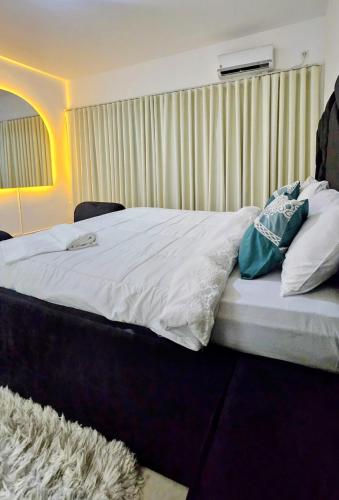 a bedroom with a bed with white sheets and pillows at Entire Space T3 Centralidade do Kilamba, Luanda in Luanda