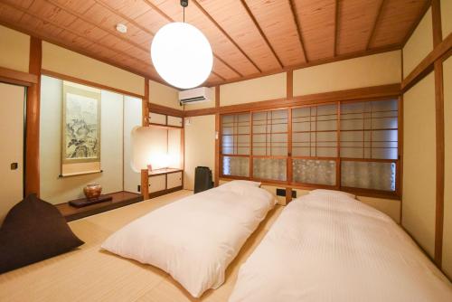 a room with two white pillows on a bed at あかり by 4S STAY in Uchiko