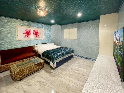 a bedroom with a bed and a chair in it at Hotel BaliBali 熊本 in Kumamoto