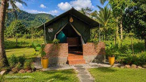 a green tent with a door in a garden at COCO FOREST CAMPING - Luxury Glamping & Villa - ONLY FOR FOREIGN BOOKINGS in Kurunegala