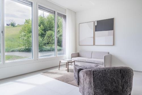 a living room with a couch and a window at Rigi Lakeside Apartments in Merlischachen