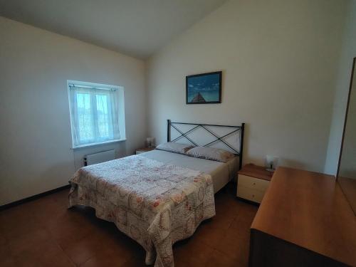a bedroom with a bed and a window at Rustico Lo Scarpone in Camaiore