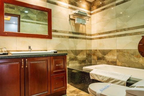a bathroom with a sink and a tub and a toilet at Balcony Superior King - Châu Giang Hotel in Ga Phú Trung