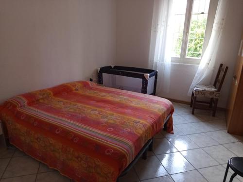 a bedroom with a bed and a chair and a window at Appartamento Rosa in Savio di Ravenna