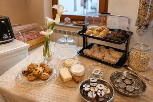 a table with various types of bread and pastries at Borgo Paradiso Guest House in Maccagno Inferiore