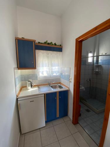 a small kitchen with a sink and a shower at Hotel Helena in Ios Chora