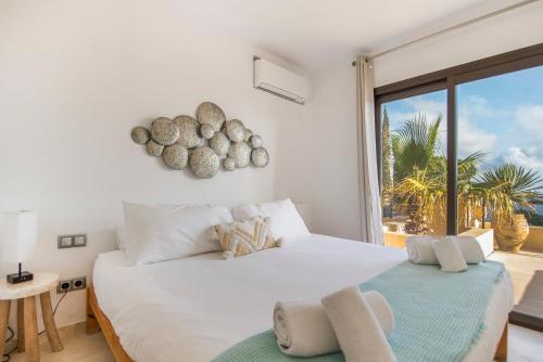 a bedroom with a large white bed and a large window at La Villa in Illes Balears