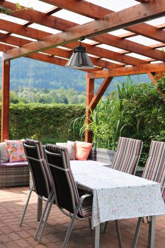 a table and chairs on a patio with a pergola at Lenz Stay - Ganzes Ferienhaus mit privatem Garten in Kaisersberg
