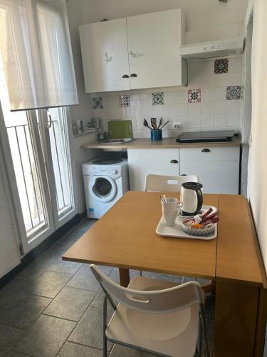 a kitchen with a wooden table with chairs and a microwave at Cà Bartolomeo in Finale Ligure