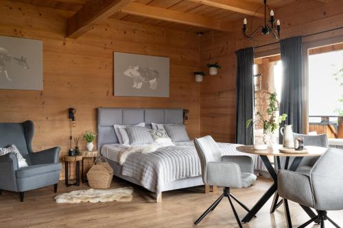 a bedroom with a bed and two chairs and a table at Wierchowa Chata in Kościelisko