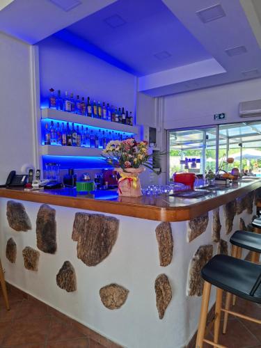 a bar in a restaurant with blue lighting at Angela Hotel & Apartments in Gouvia