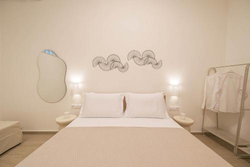 ein Schlafzimmer mit einem Bett und einem Spiegel an der Wand in der Unterkunft Corali 2 - Coastal Retreat in Katakolo