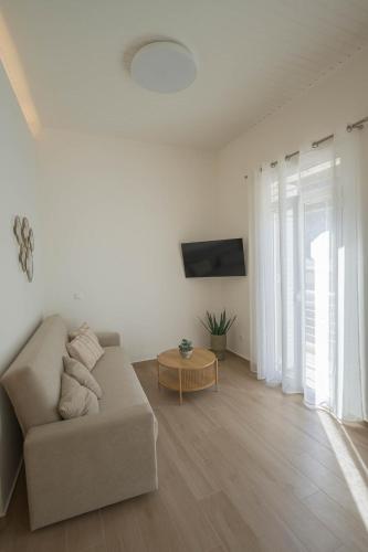 ein Wohnzimmer mit Sofa und Tisch in der Unterkunft Corali 2 - Coastal Retreat in Katakolo
