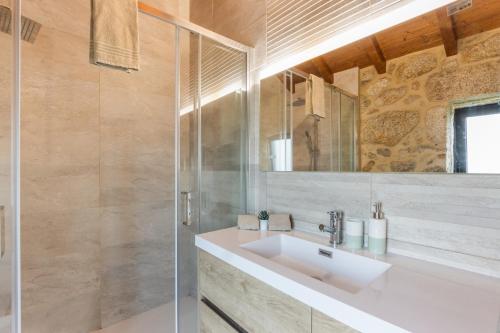 a bathroom with a sink and a mirror at Casa De Pedra D'alborinhas in Arões