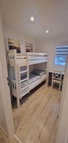a bedroom with white bunk beds in a room at Tiny House Milena in Greifswald