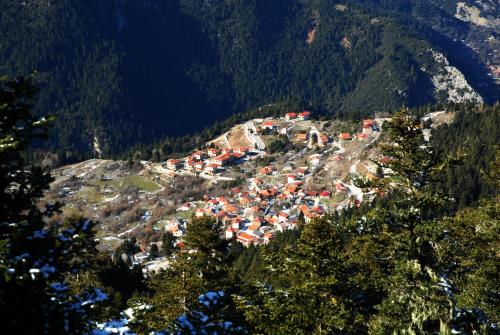 a group of houses on a hill in the mountains at Omalia Village in Áno Khóra