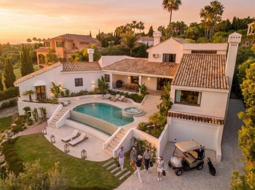 a group of people standing in front of a house at Villa Kahuna Sotogrande in Sotogrande