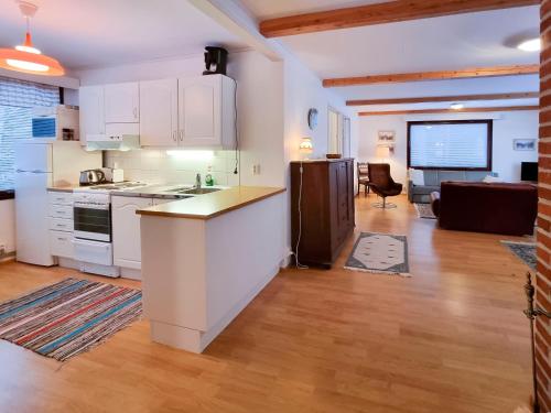 a kitchen with white cabinets and a living room at Villa Sundet in Svartön