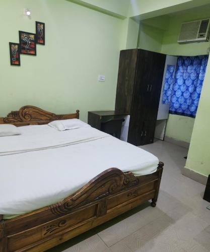 a bedroom with a wooden bed in a room at SWAYAMSIDDHA continental in Kendrāparha