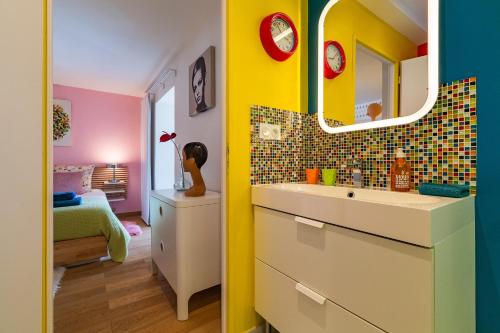 a bathroom with a sink and a mirror at La Maison Pop avec Piscine Privée in Romans-sur-Isère