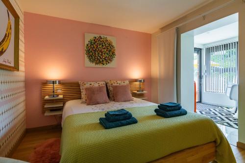a bedroom with a bed with towels on it at La Maison Pop avec Piscine Privée in Romans-sur-Isère