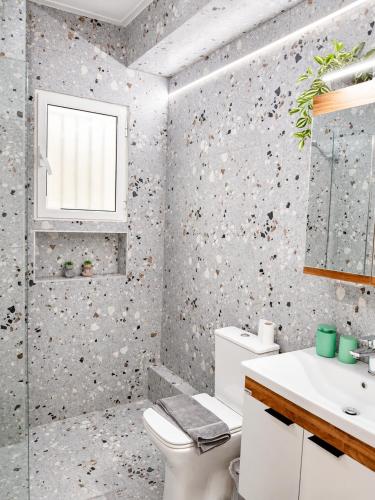 a bathroom with a toilet and a sink at Thalassia Pefkias Apartment in Xylokastro