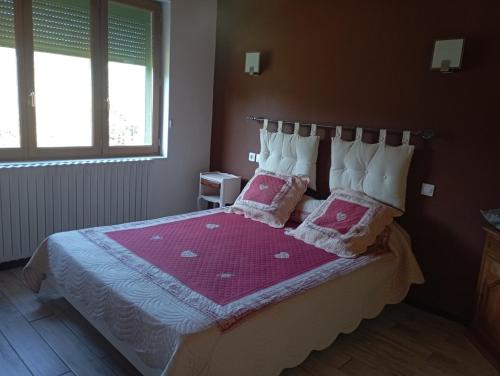 a bedroom with a bed with two pillows on it at La Chênaie Gîte in Sampzon