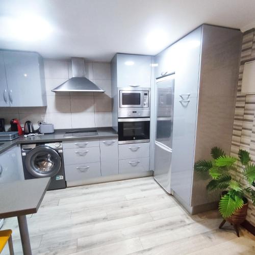 a kitchen with a refrigerator and a microwave at Apartamento céntrico Irene IV in Avilés