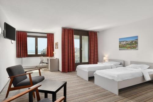 a hotel room with two beds and a desk at Neuchâtel City Hôtel - Self Check-In in Neuchâtel
