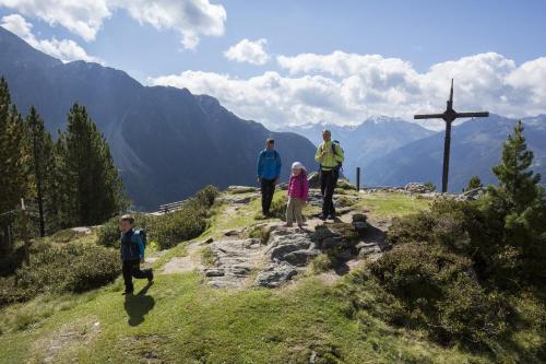 a group of people standing on a hill near a cross at Landhaus Ambachhof in Oetz