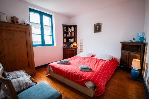 a bedroom with a bed with a red blanket at Chambre privative Dives Cabourg in Dives-sur-Mer