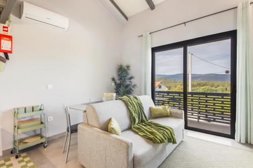 a living room with a couch and a sliding glass door at Olive Studios in Campo de Arca