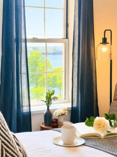 a bed with a table with a book and a window at Fox Point Landing Residences in Providence