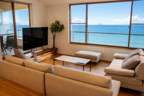 a living room with a couch and a flat screen tv at Villa JacoO 2 in Sanuki