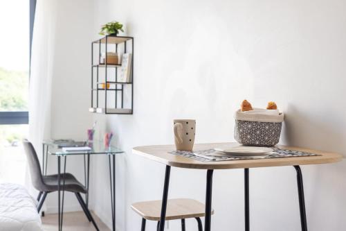 a table in a room with a bed and a chair at 108 - L'Obsidienne - Wifi in Achères