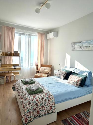 a bedroom with a bed and a chair in it at Skyline 11B Apartment - Sea View,Pools & SPA in Varna City