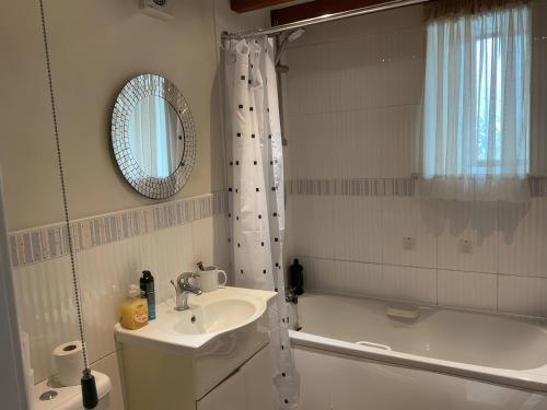 a bathroom with a sink and a tub and a mirror at The Cottage in Middlesbrough