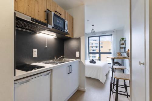a kitchen with a sink and a stove top oven at 208 - L'Obsidienne - Wifi in Achères