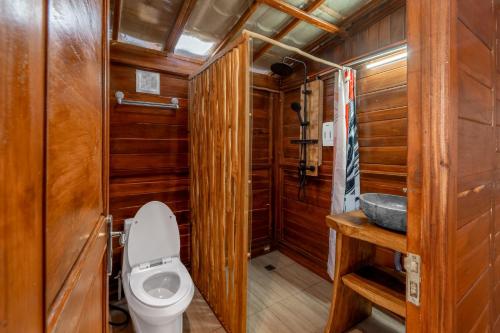 a bathroom with a toilet and a sink at Kamani Cabin by Moria in Kubupenlokan
